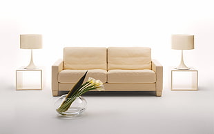 beige leather 2-cushion sofa beside end table and table lamps